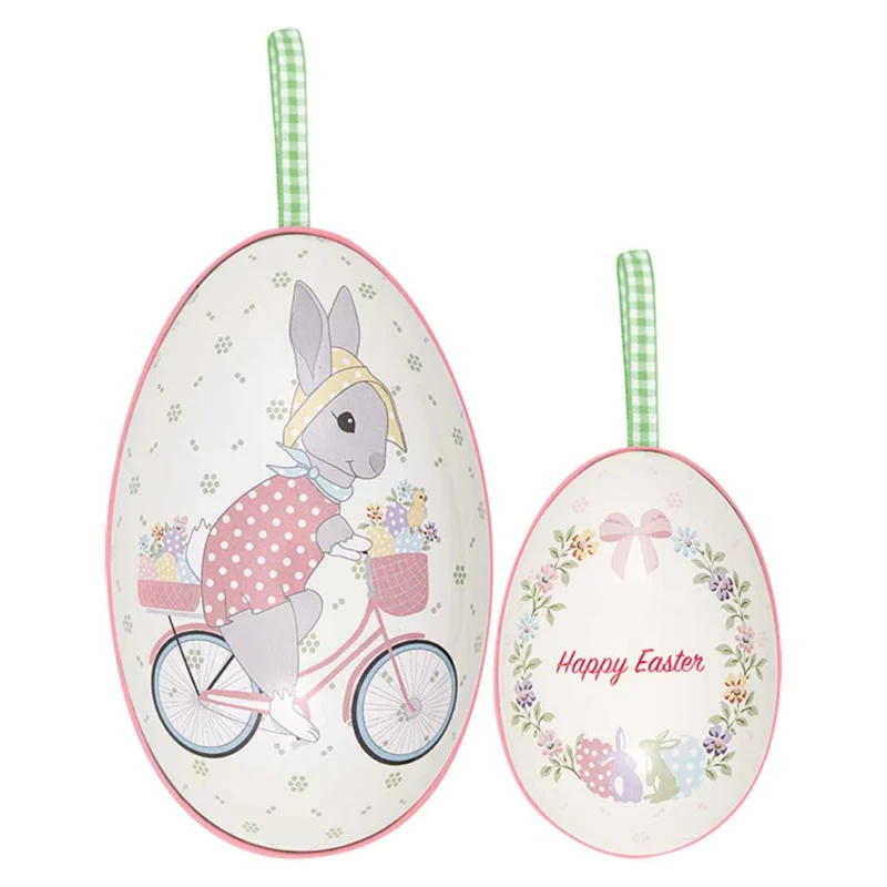 Zwei weiße Wandbehänge von GreenGate - Silja Deko-Ei 2er-Set mit Illustrationen eines Hasen auf einem Fahrrad und einer „Frohe Ostern“-Botschaft.