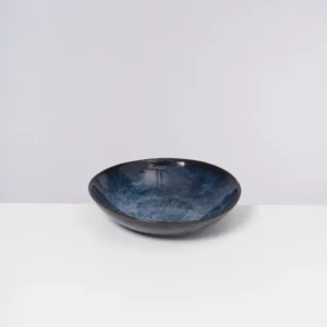 Blau-schwarze Keramikschale auf weißem Hintergrund.