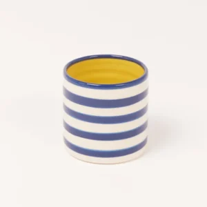 Keramikbecher mit blauen und weißen Streifen, innen gelb.